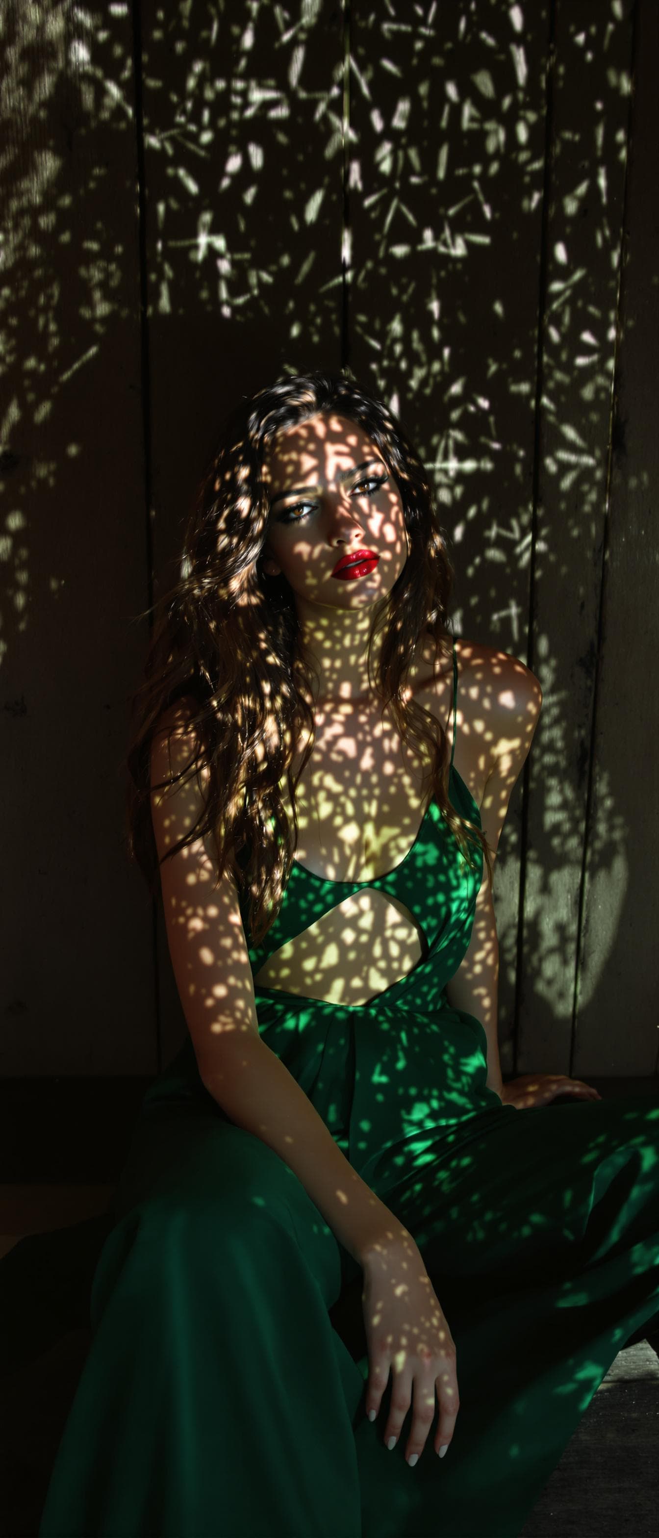 AI generated: A stunning supermodel with long, flowing hair sits on a rustic wood texture background, dressed in a...