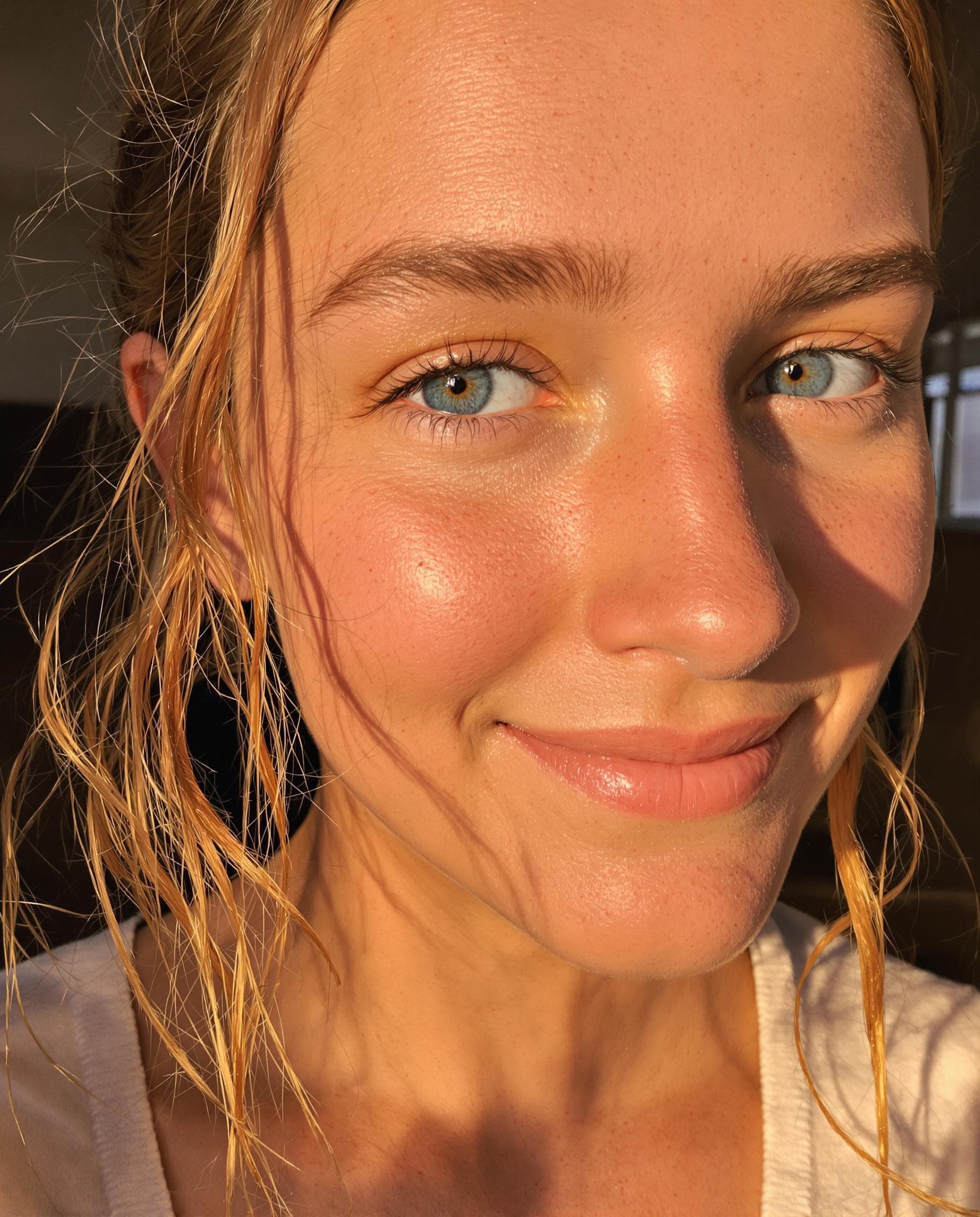 AI generated: low quality phone photo, snapchat, a close-up of a girl's face with warm blue eye's, wavy auburn hai...
