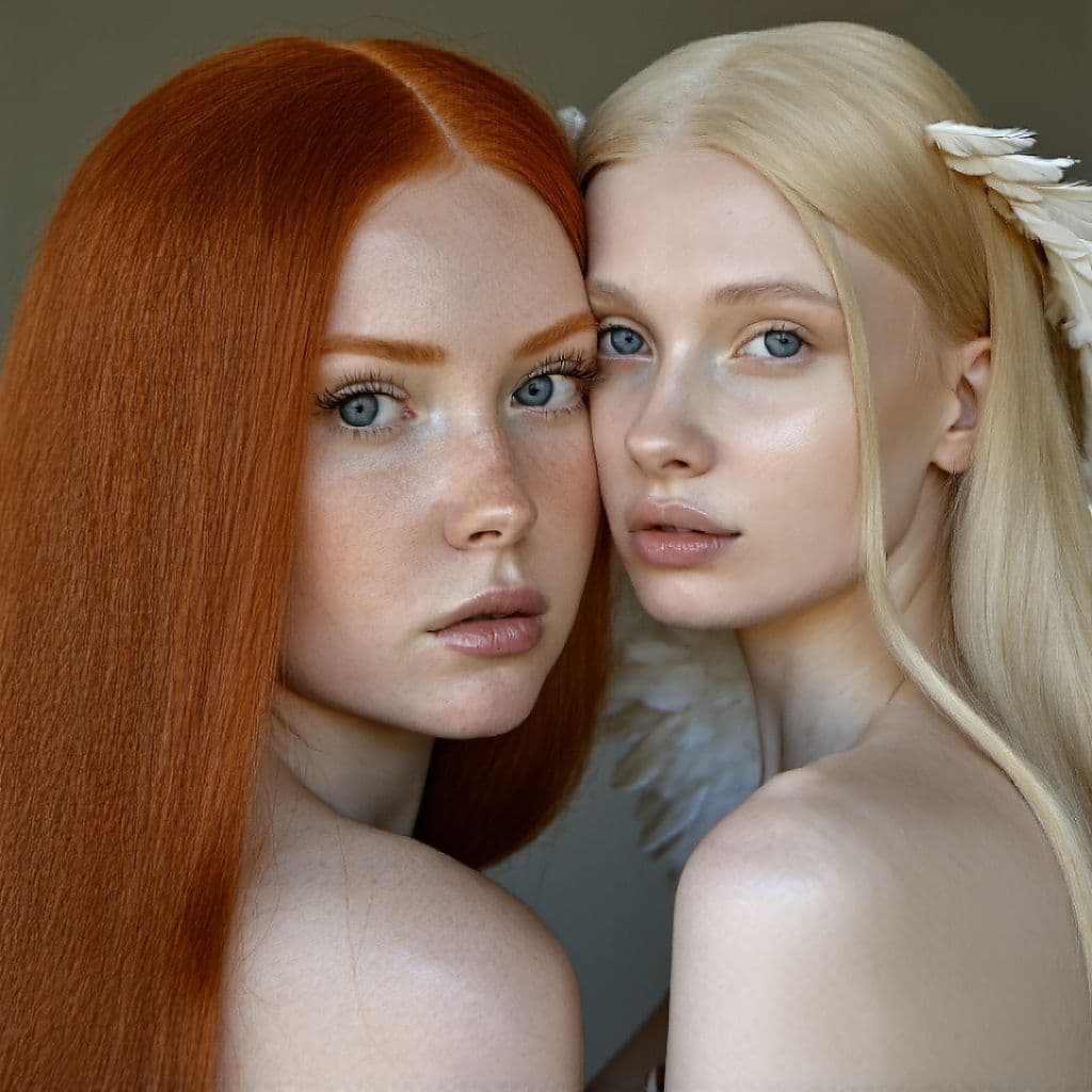 AI generated: Hyper realistic photograph of a blonde with an angelic face sits next to a redhead with a round face...