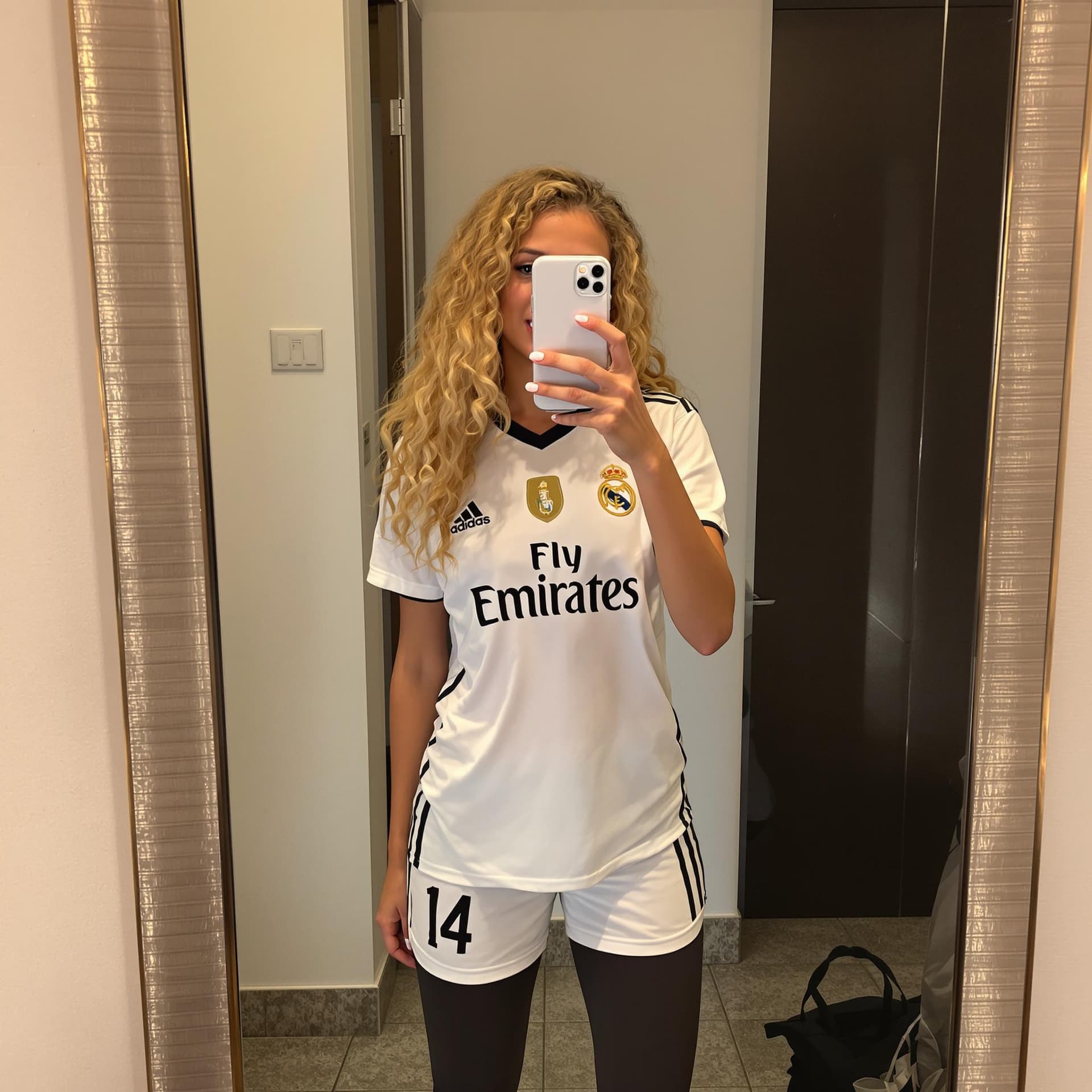 AI generated: Hot italian 16-year-old girl with blonde long curly hair taking a photo at a mirror in a hotel room ...