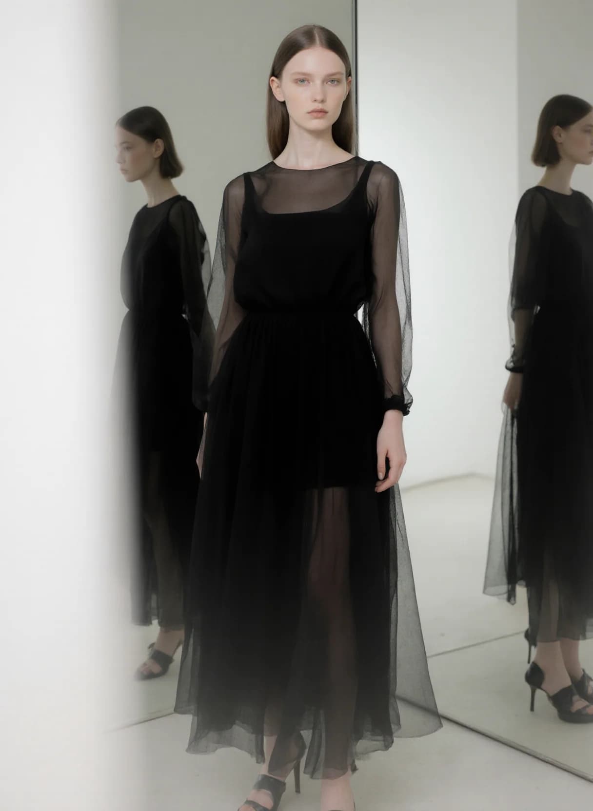 AI generated: A model stands poised in a minimalist, modern setting, her reflection mirrored in a large, sleek mir...