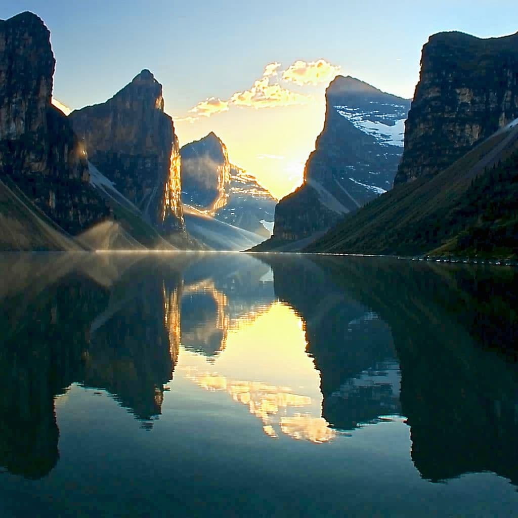 AI generated: A majestic mountain canyon stretches between towering, ancient rock cliffs. A sunset over the lake r...