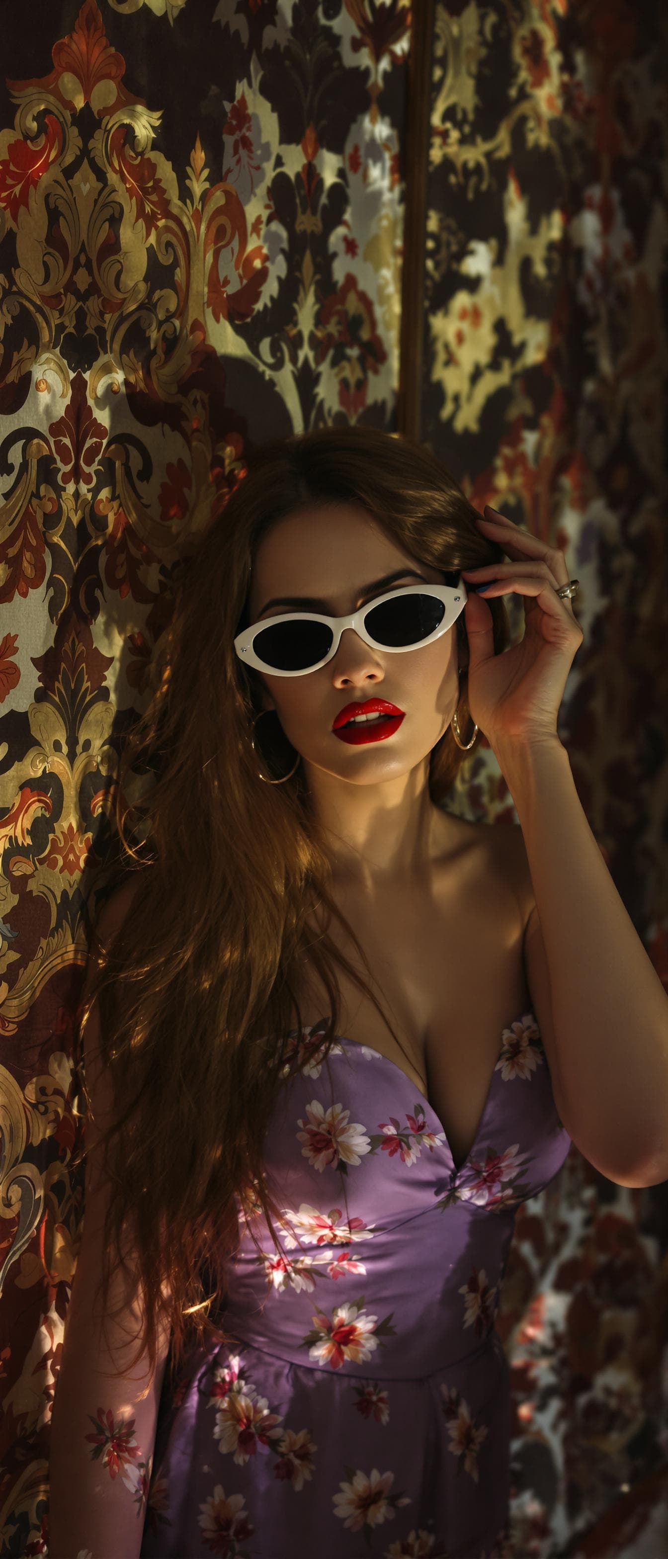 AI generated: A sultry, sensuous woman with long, flowing hair dressed in a lavender floral dress leans forward, h...