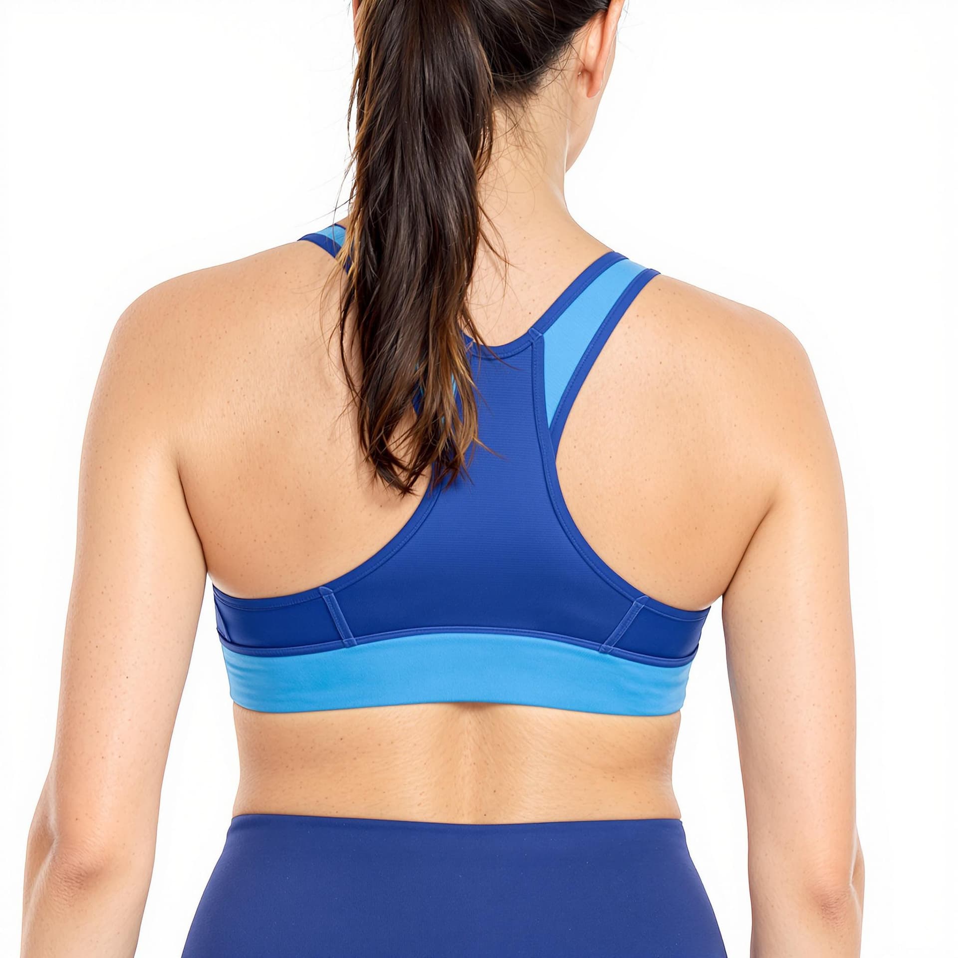 AI generated: a woman wearing blue sports bra and matching leggings. Her hair is pulled back in a ponytail. The ba...