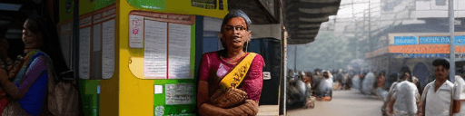 AI generated: indian woman in saree waiting for a bus in a busy Mumbai street