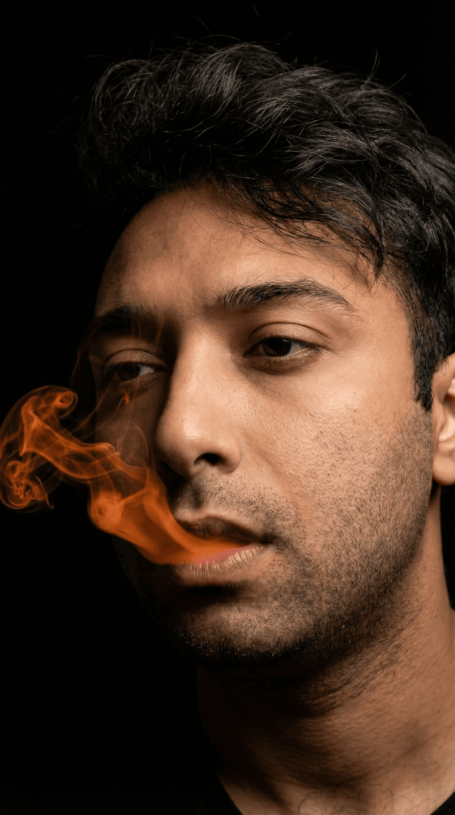 AI generated: cinematic close-up of a young man with vibrant orange smoke curling from his lips against a solid bl...