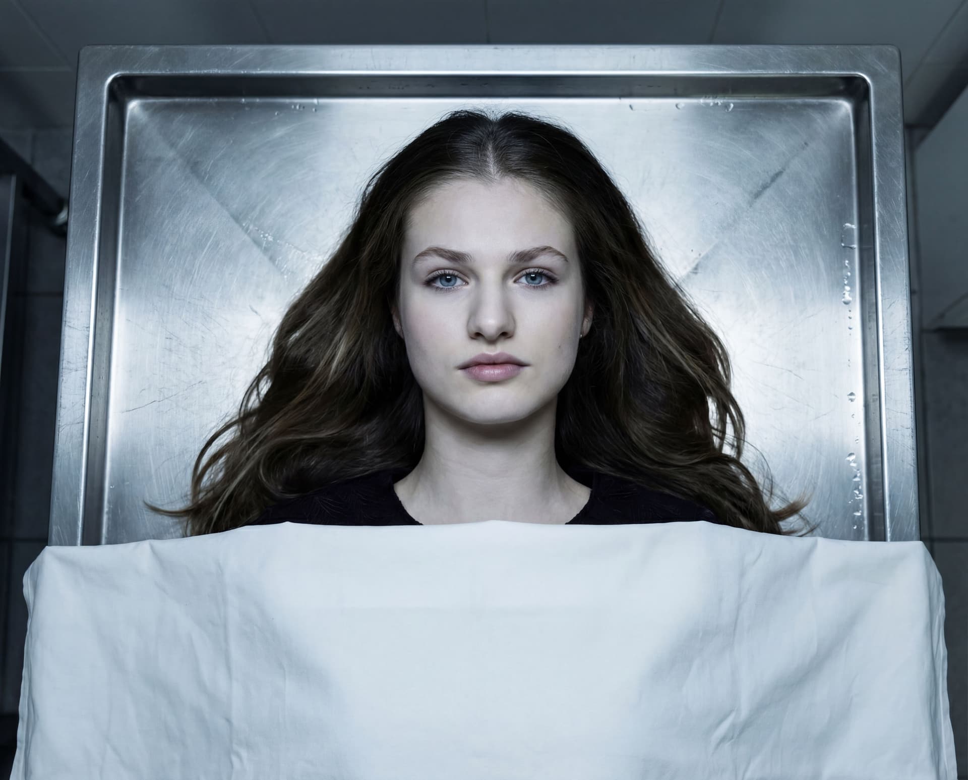 AI generated: A hauntingly realistic depiction of a dead girl lying motionless on a cold morgue table, opened eyes...