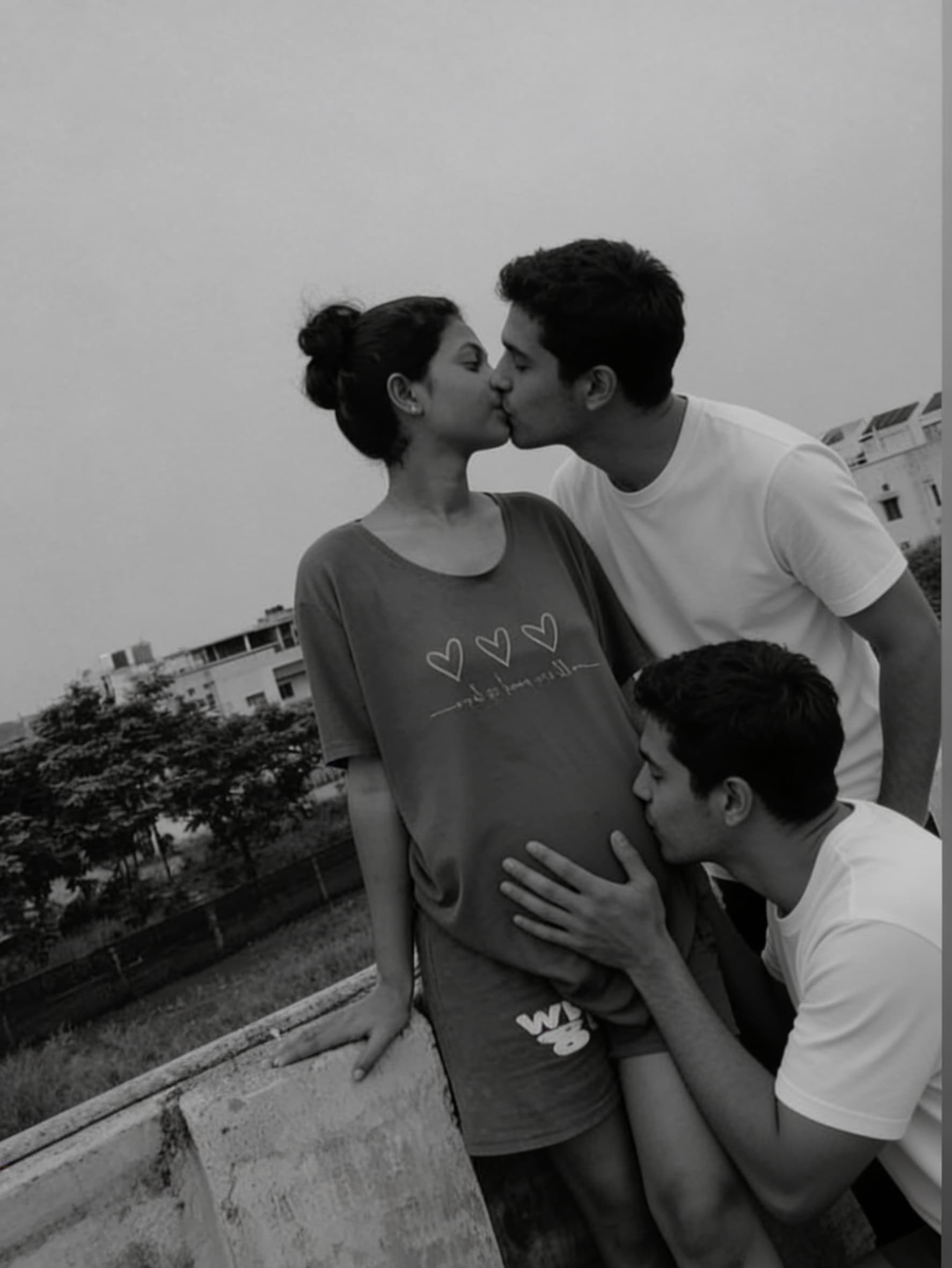 AI generated: One guy kissing the woman lips and second guy kissing the woman belly