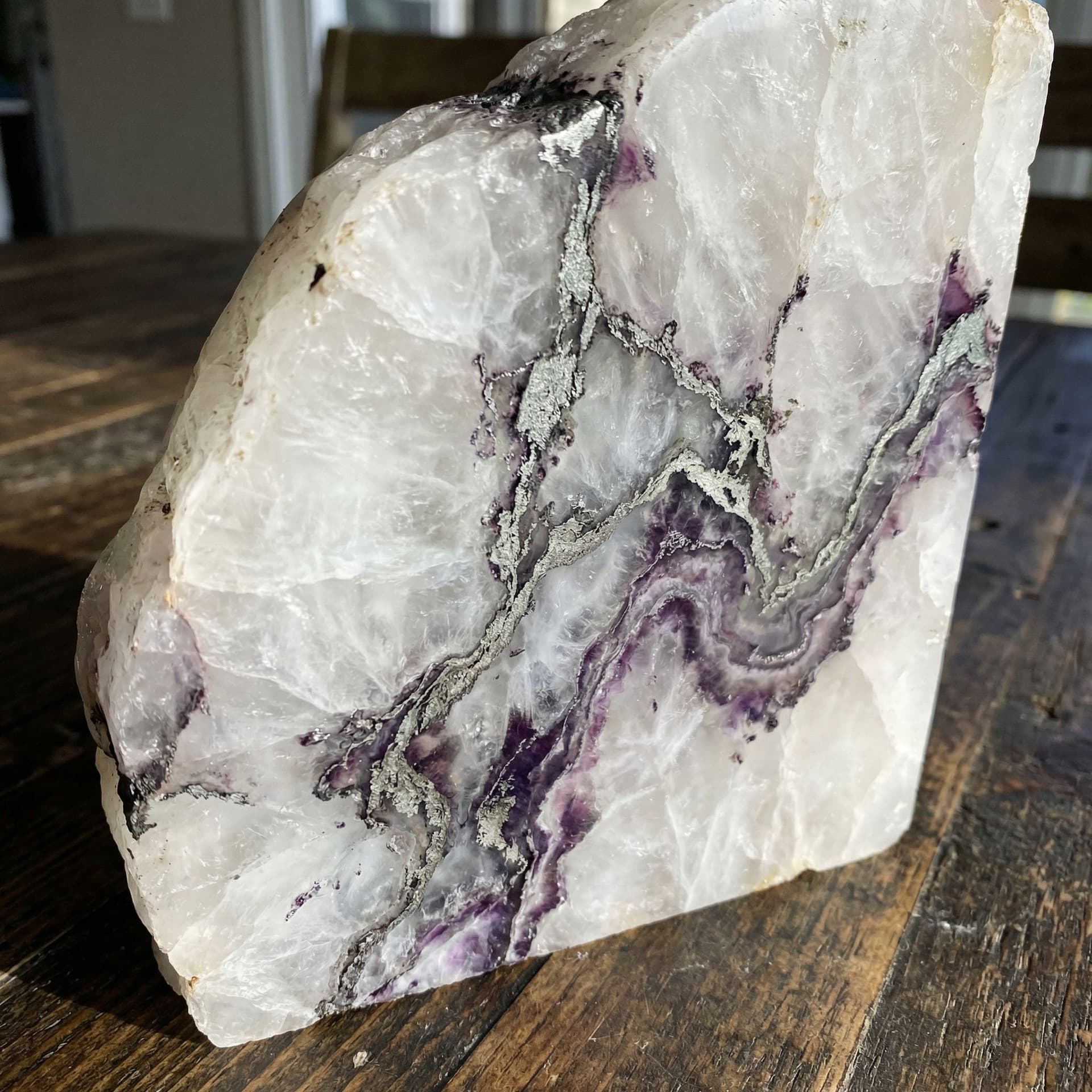 AI generated: A Solid white crystal with a lot of veins of silver and purple running through it like marble 