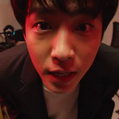 AI generated video: POV vlog-style shot in a dark room lit by red light, a person looks nervously into the camera and ta...