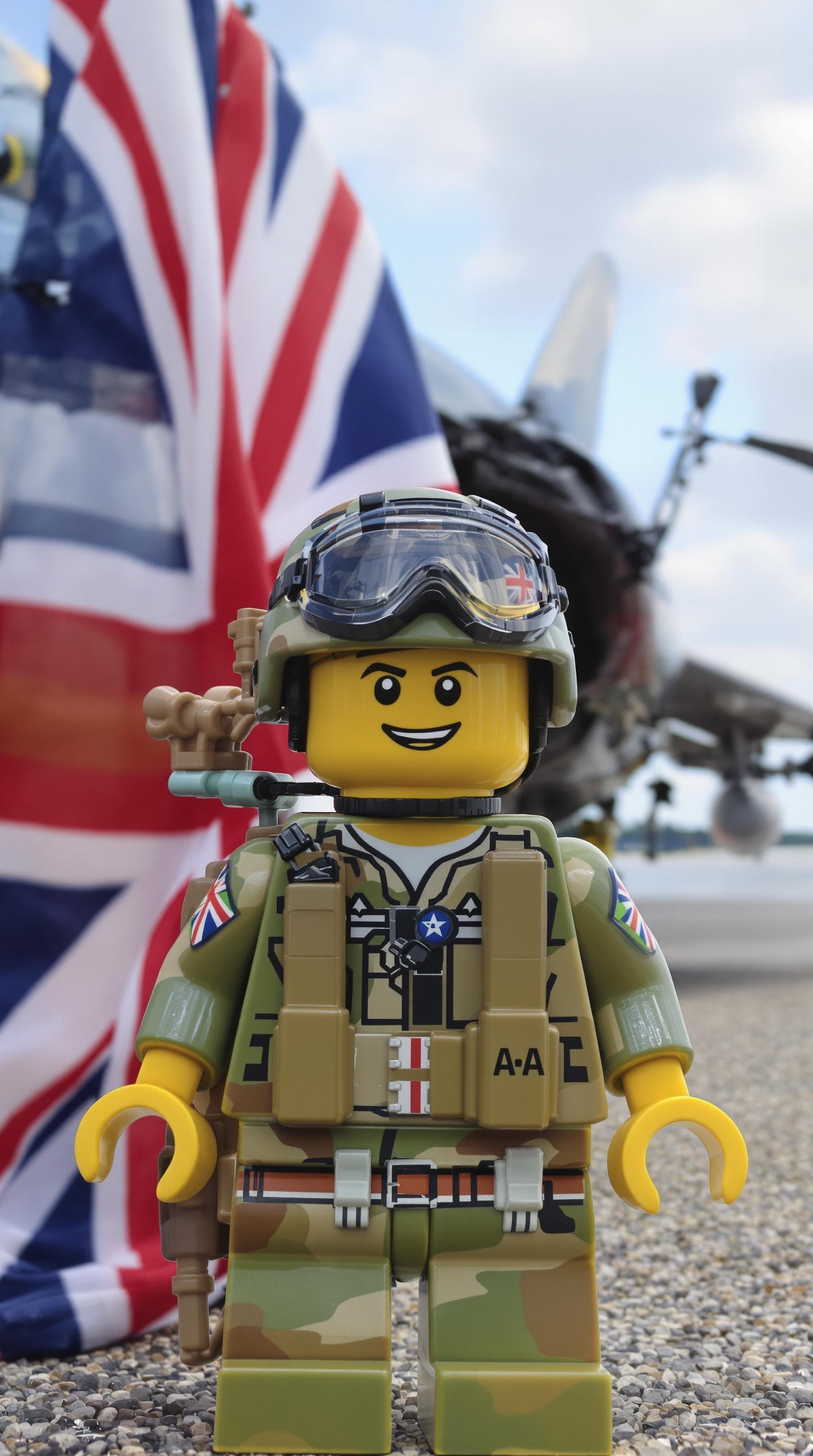 AI generated: A LEGO character dressed in British military gear in front of a fighter jet with a British flag in t...