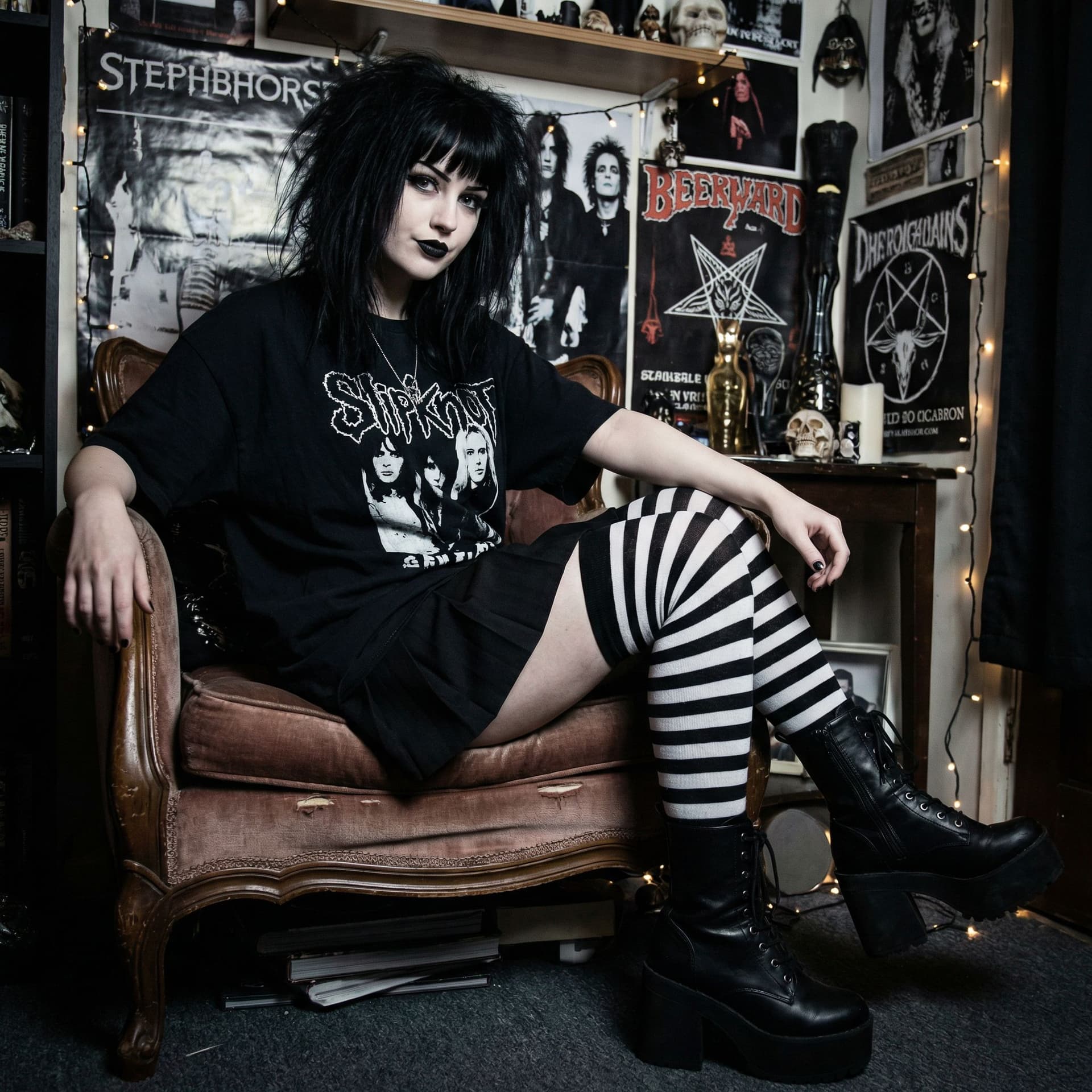 AI generated: a goth girl, she has black hair and lips, and she is wearing a black tshirt and black and white stoc...