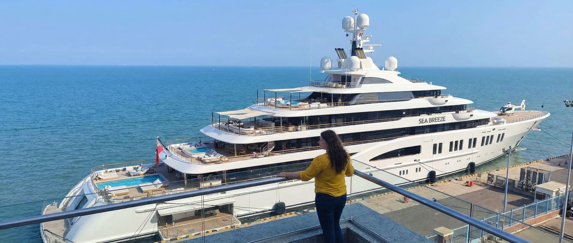 AI generated: Crea un barco de lujo en el mar que se vea atracado cerca del muelle y se muestre la envergadura de ...