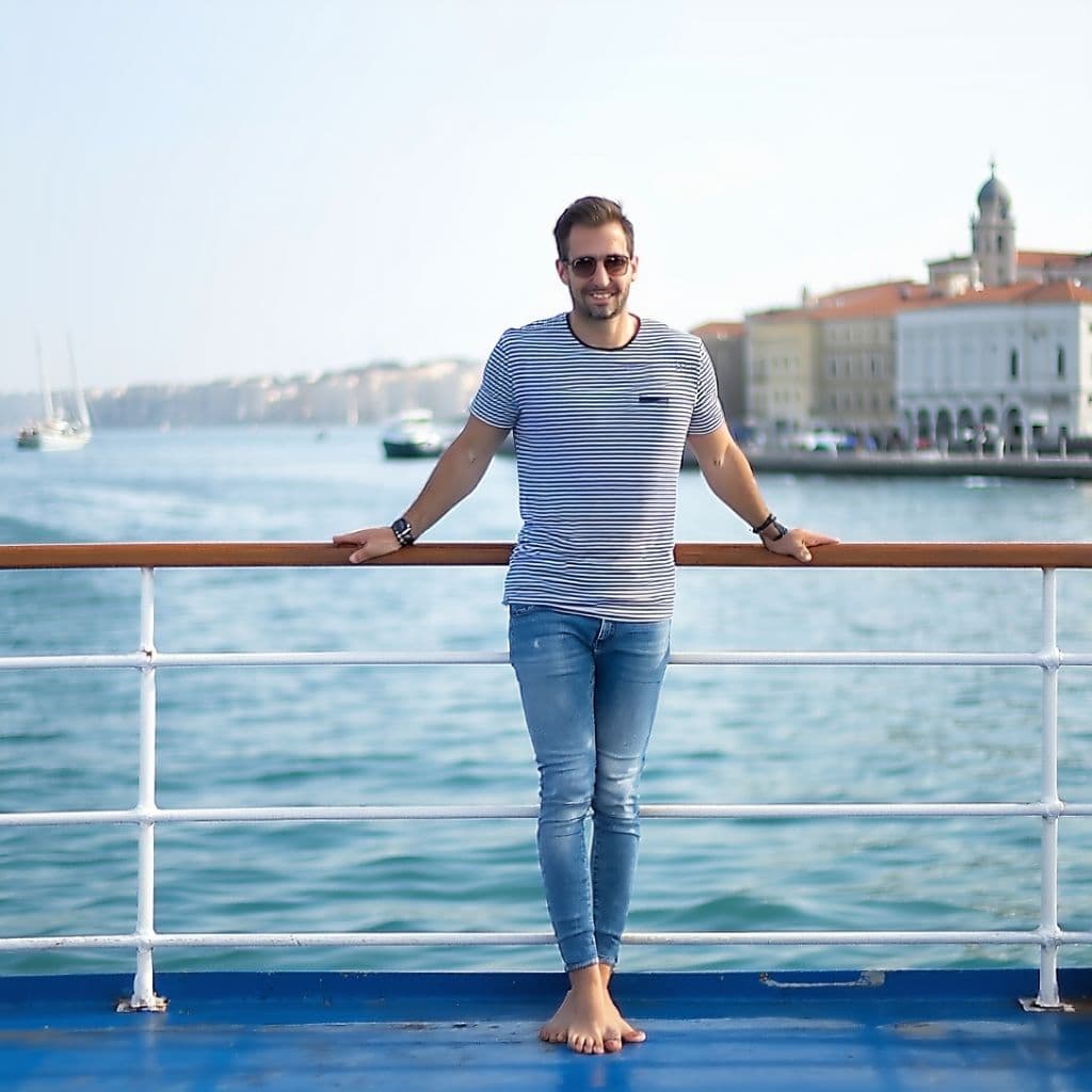 AI generated: create a image for this "A man standing on a boat deck, looking at the camera." in a striped shirt a...