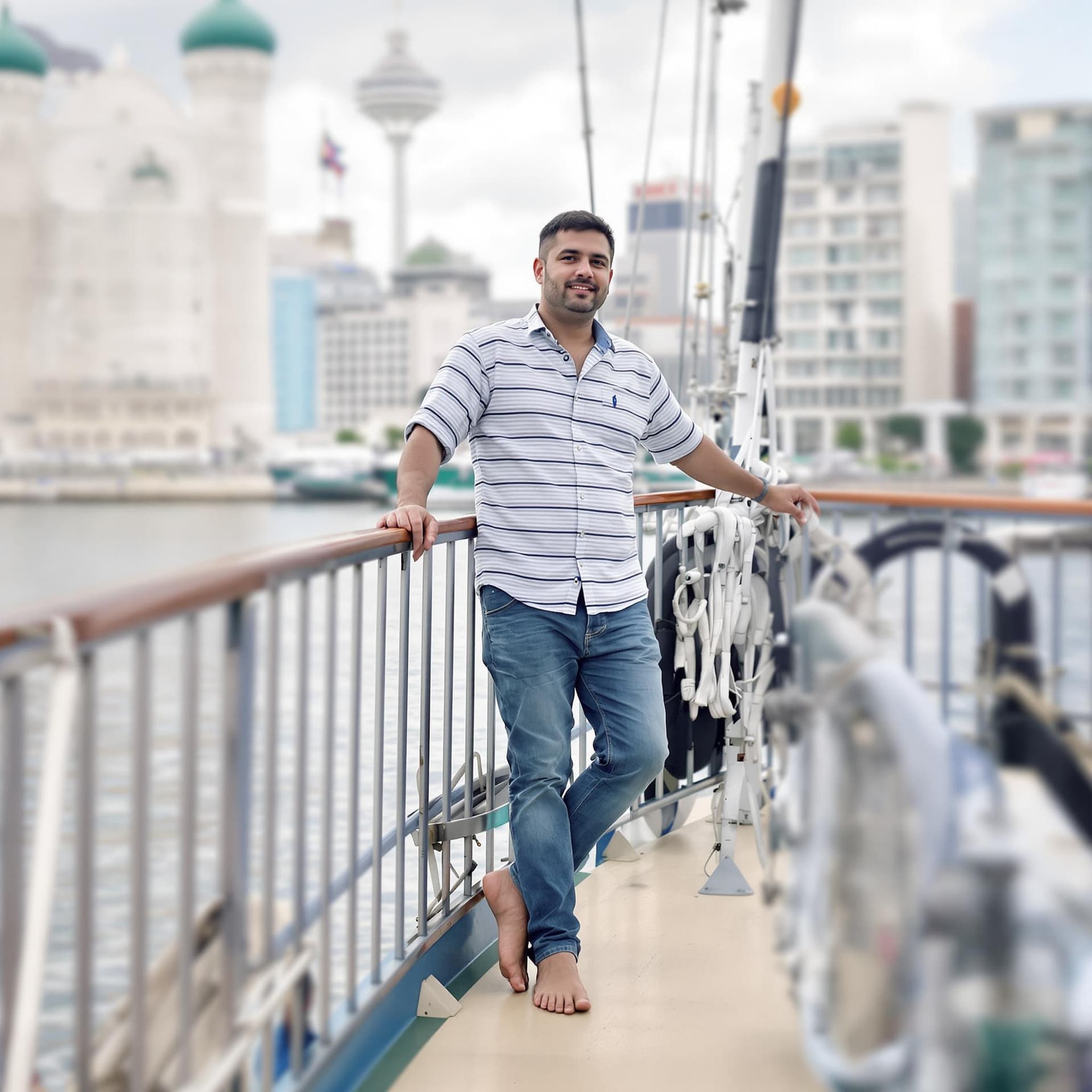 AI generated: create a image for this "A man standing on a boat deck, looking at the camera." in a striped shirt a...