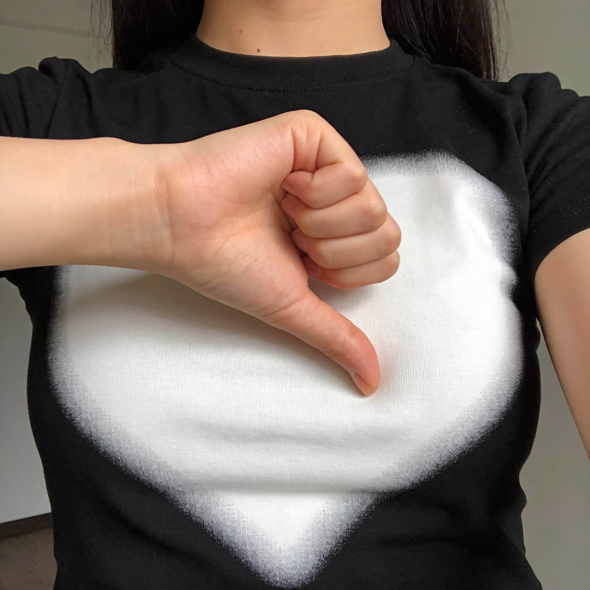 AI generated: A girl wearing a black t-shirt with a prominent, white chest takes a selfie of her chest and places ...