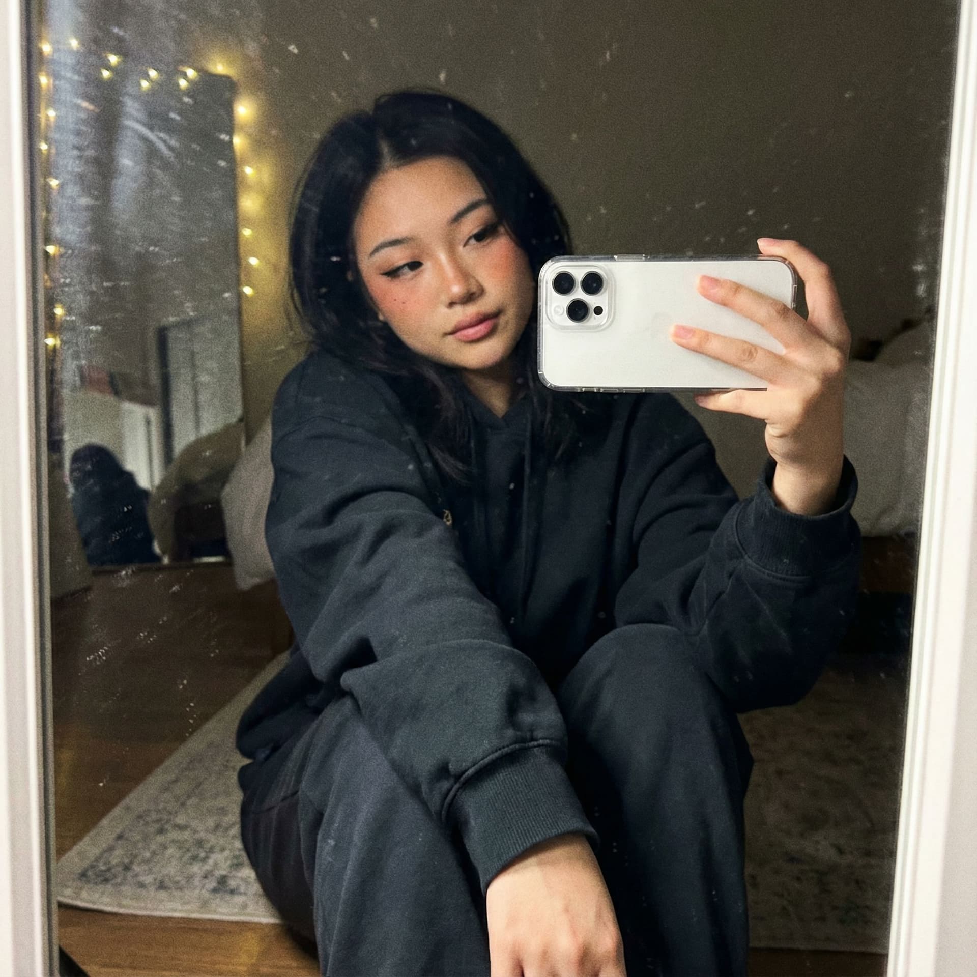 AI generated: A realistic mirror selfie of a cute asian e-girl, 20 y.o., taken with iPhone white 16 Pro Max held i...