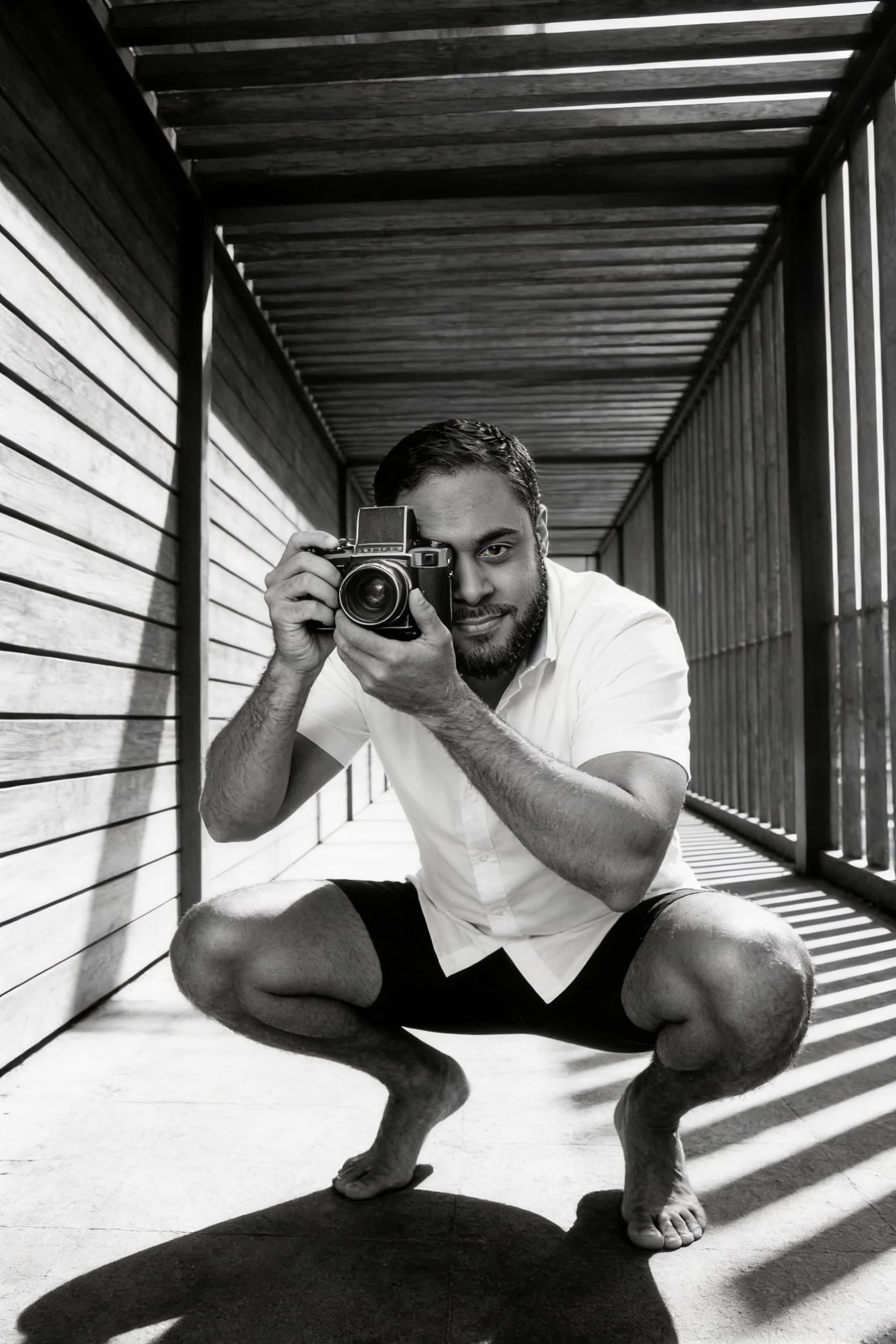 AI generated: High-contrast black and white full-body photograph of a glamorous men in a low,athletic squatting po...