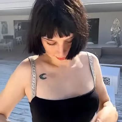 AI generated video: camera pans out quickly, she  removes her top is completly topless naked and reveals her big saggy b...