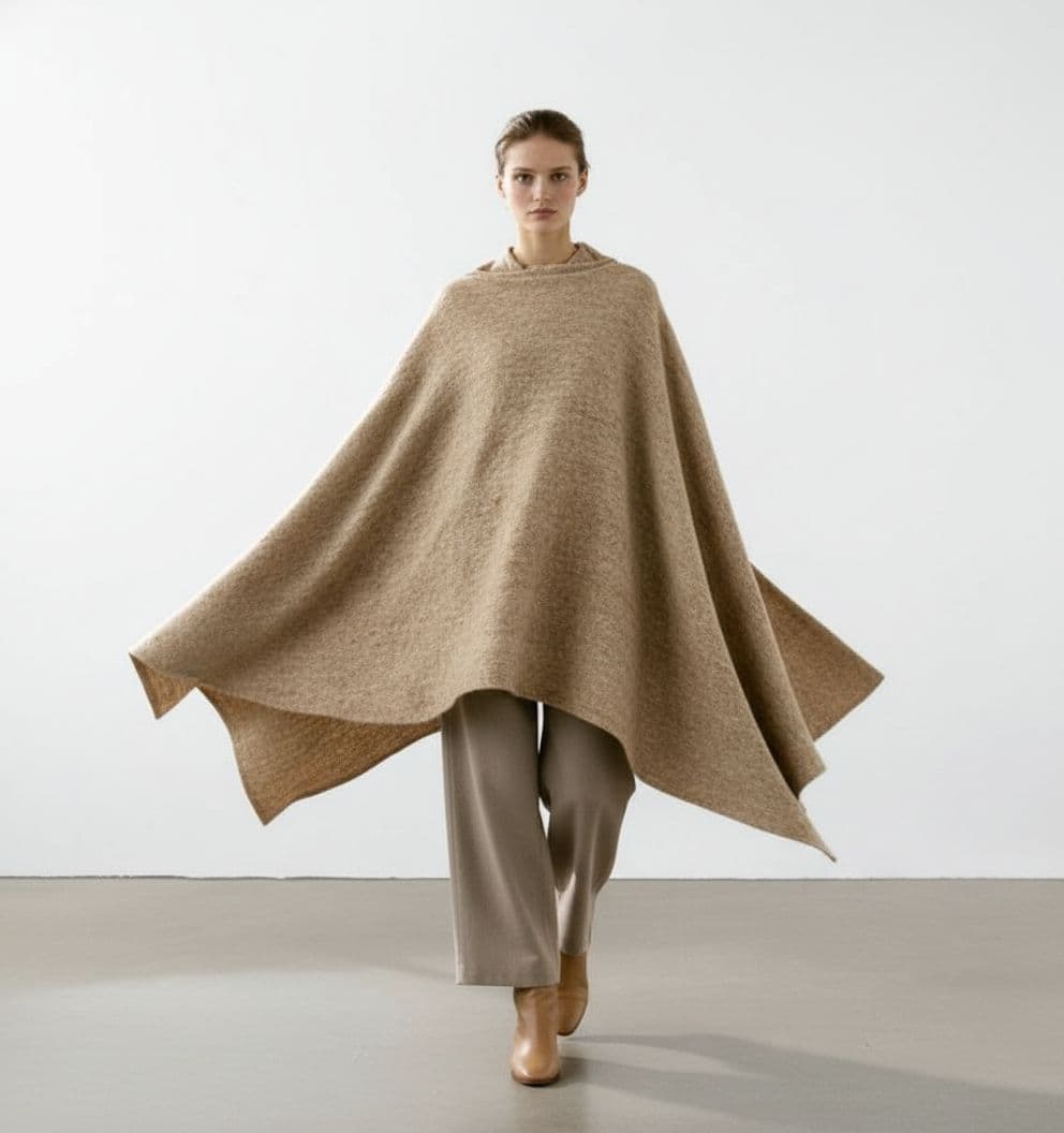 AI generated: Editorial fashion portrait featuring a person wearing an artisanal wool poncho or cape, flowing, scu...