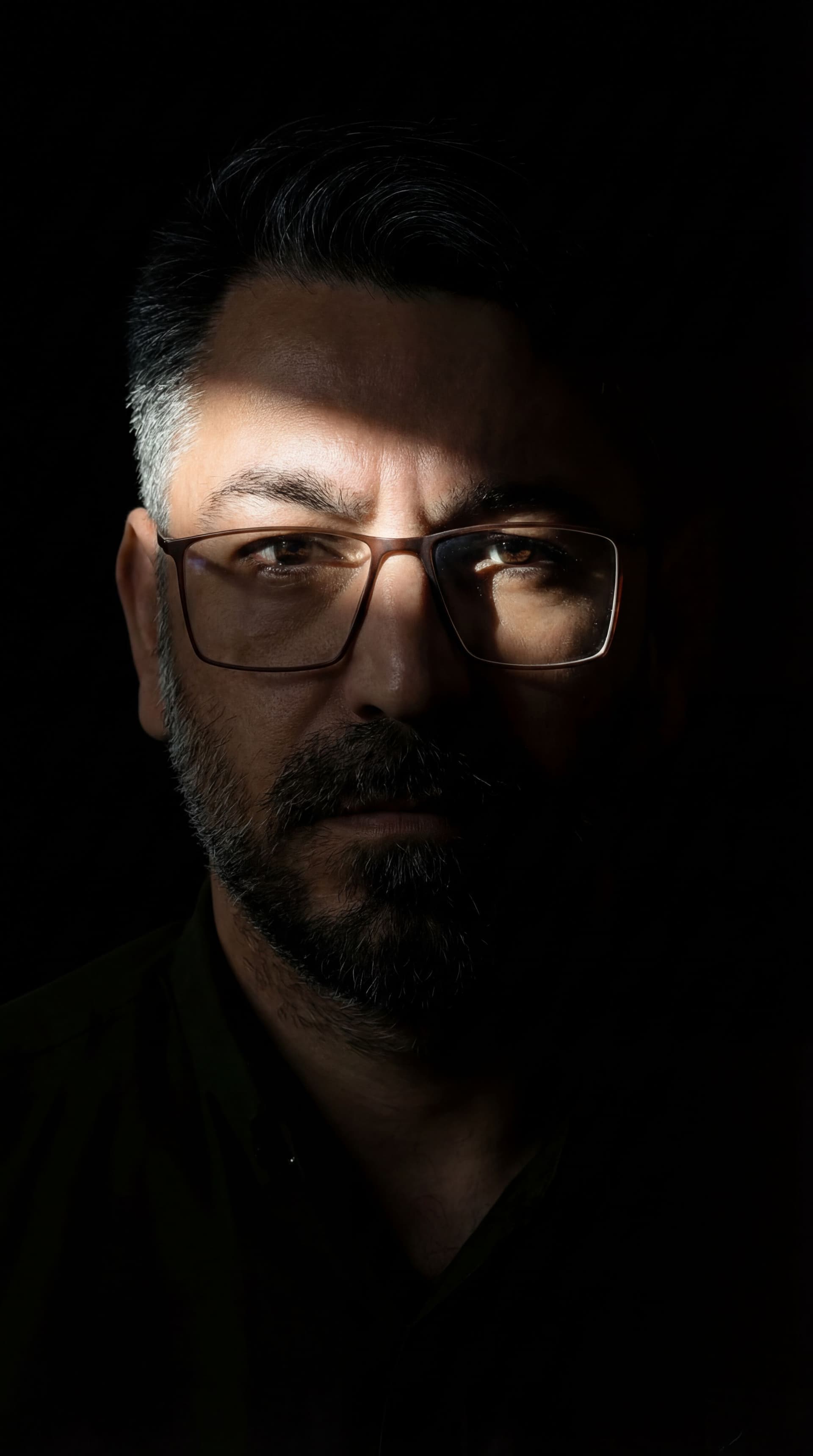 AI generated: Generate an image with an intense chiaroscuro effect. The man should retain his original features an...