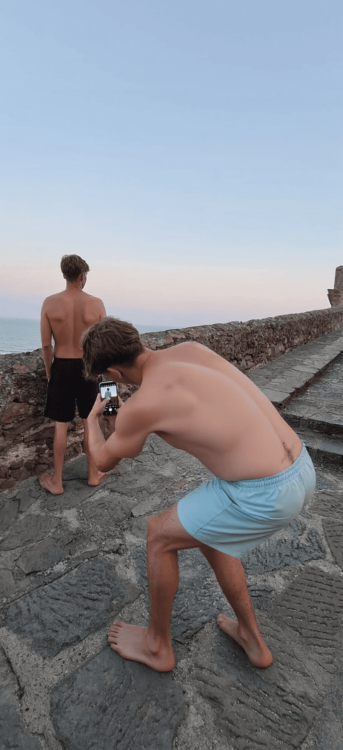AI generated: Change the outfit to swimming trunks as in beachwear. The guy having slighty hairy chest but not a t...