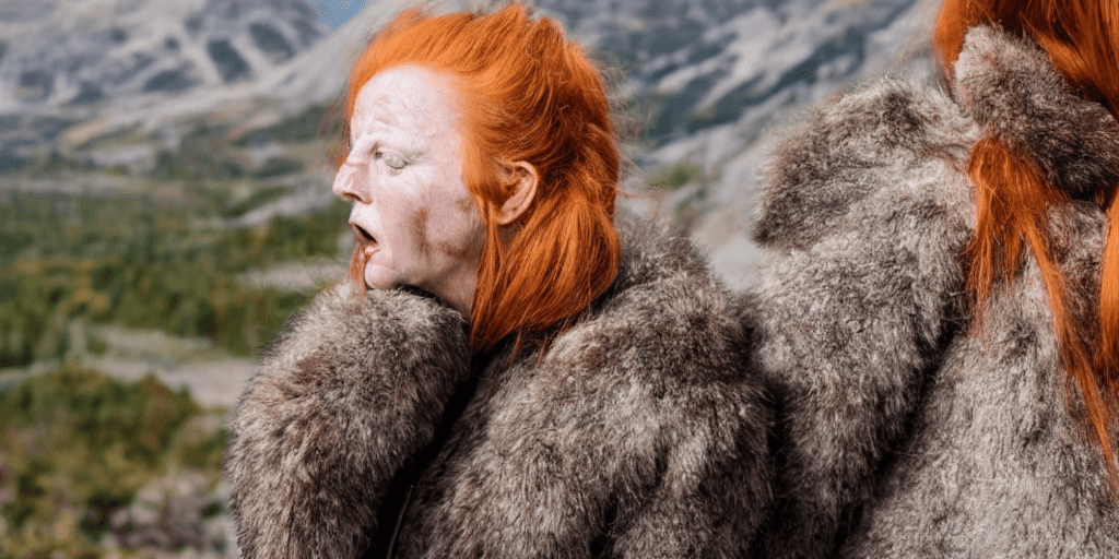 AI generated: close-up shot ginger woman, sad, talking, open mouth, worn leather, fur, walking on a hiking trail i...