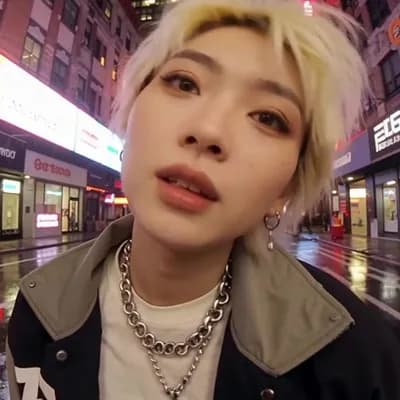 AI generated video: cinematic sequence, fisheye selfie of an Asian woman with short blonde hair, oversized XL urban stre...