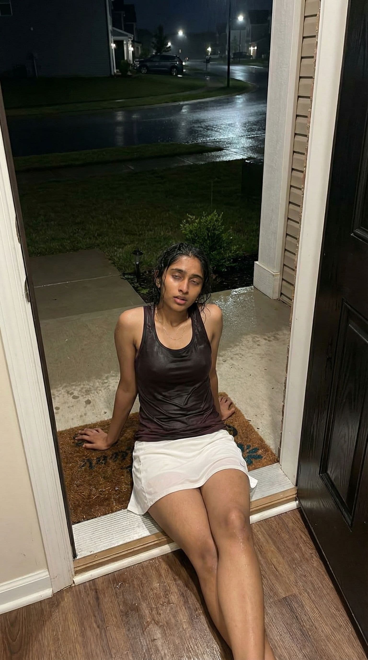 AI generated: (SORA)          Photo from an iPhone. A fit, slim beautiful brunette girl sits in front of the entra...