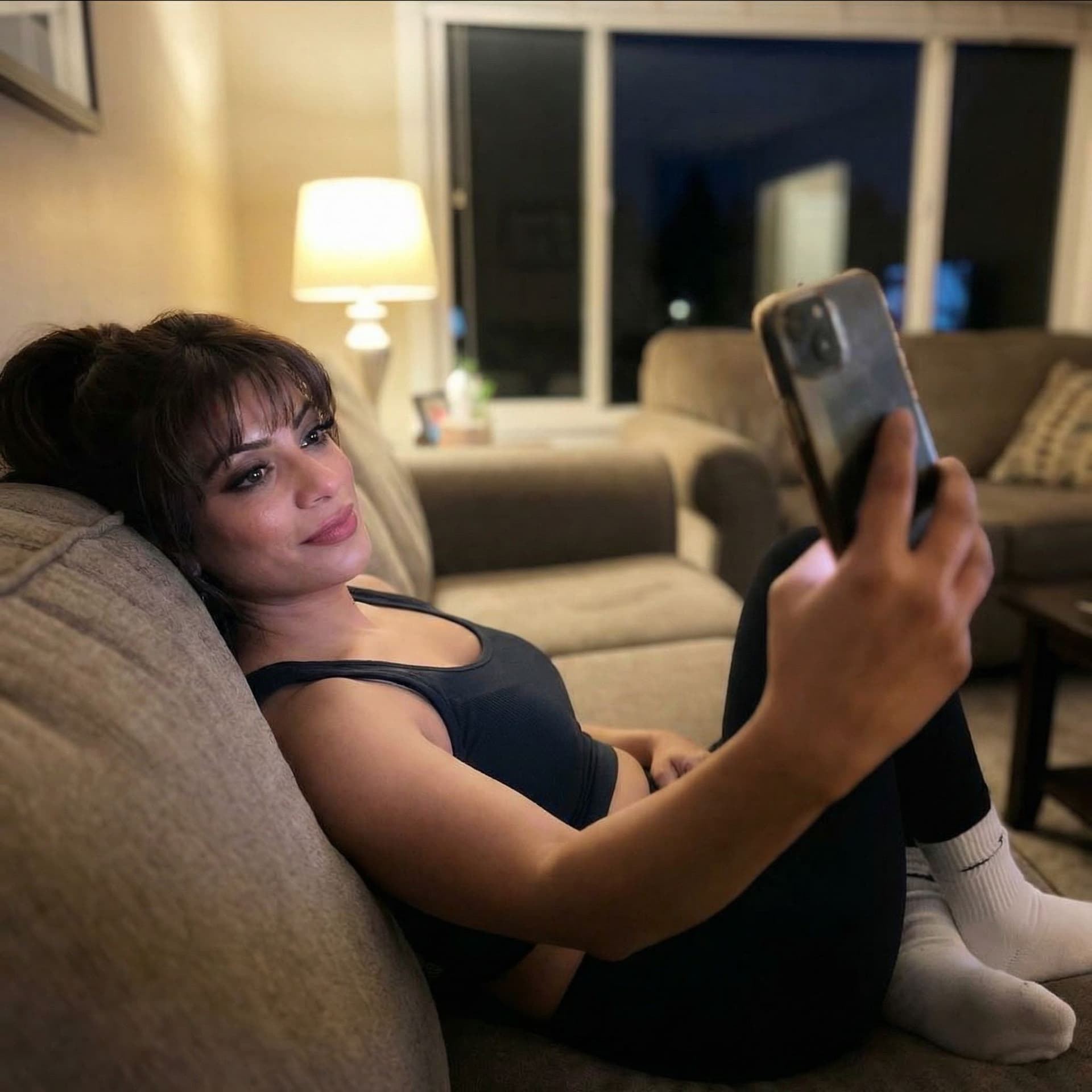 AI generated: Taking a selfie on a couch at night, wearing a cropped tanktop and white socks, dont alter original ...