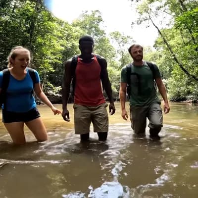 AI generated video: Handheld smartphone footage of a group of hikers wading through a shallow jungle river, surrounded b...