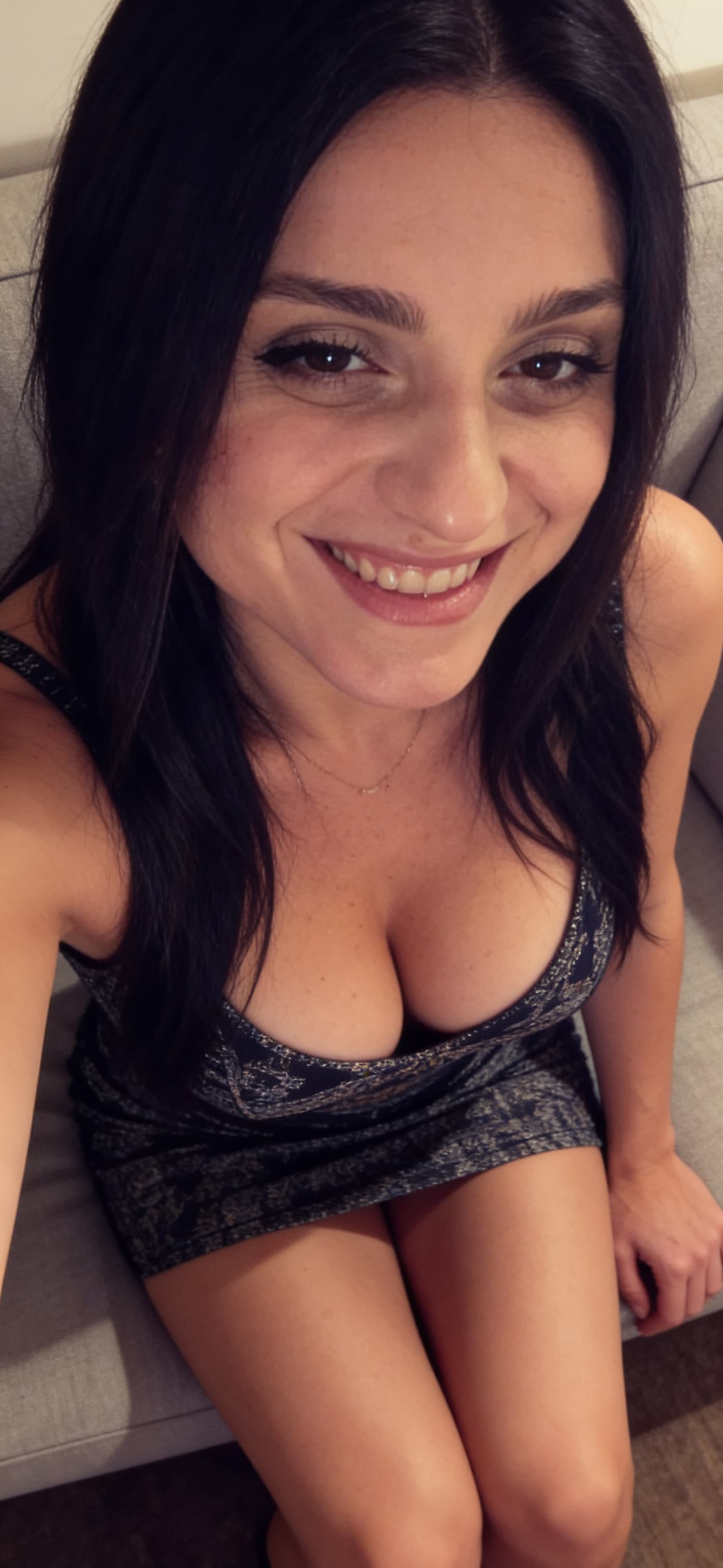 AI generated: Wearing a mini dress, sitting on a couch, close view, 35-year-old , busty body, 
