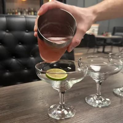 AI generated video: create a image in which making of mocktails. Pouring mixture from boston shaker into glasses    