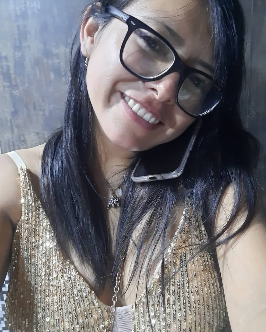 AI generated: Señorita con lentes de 30 años en llamada y sonriente.