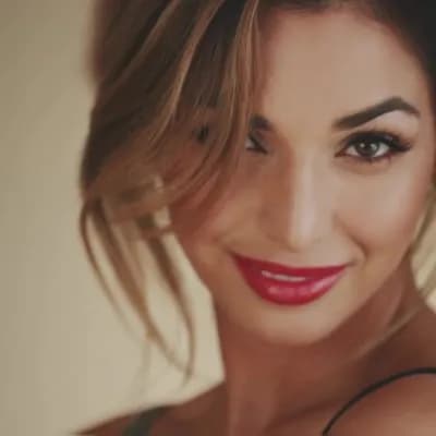 AI generated video: A confident and attractive woman looks directly into the camera with a sexy, playful gaze. She slowl...