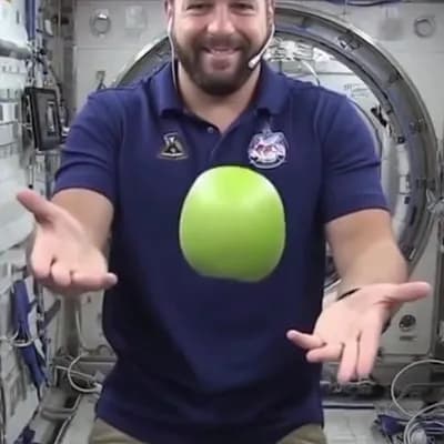AI generated video: a video of an astronaut playing with an apple inside the space station

