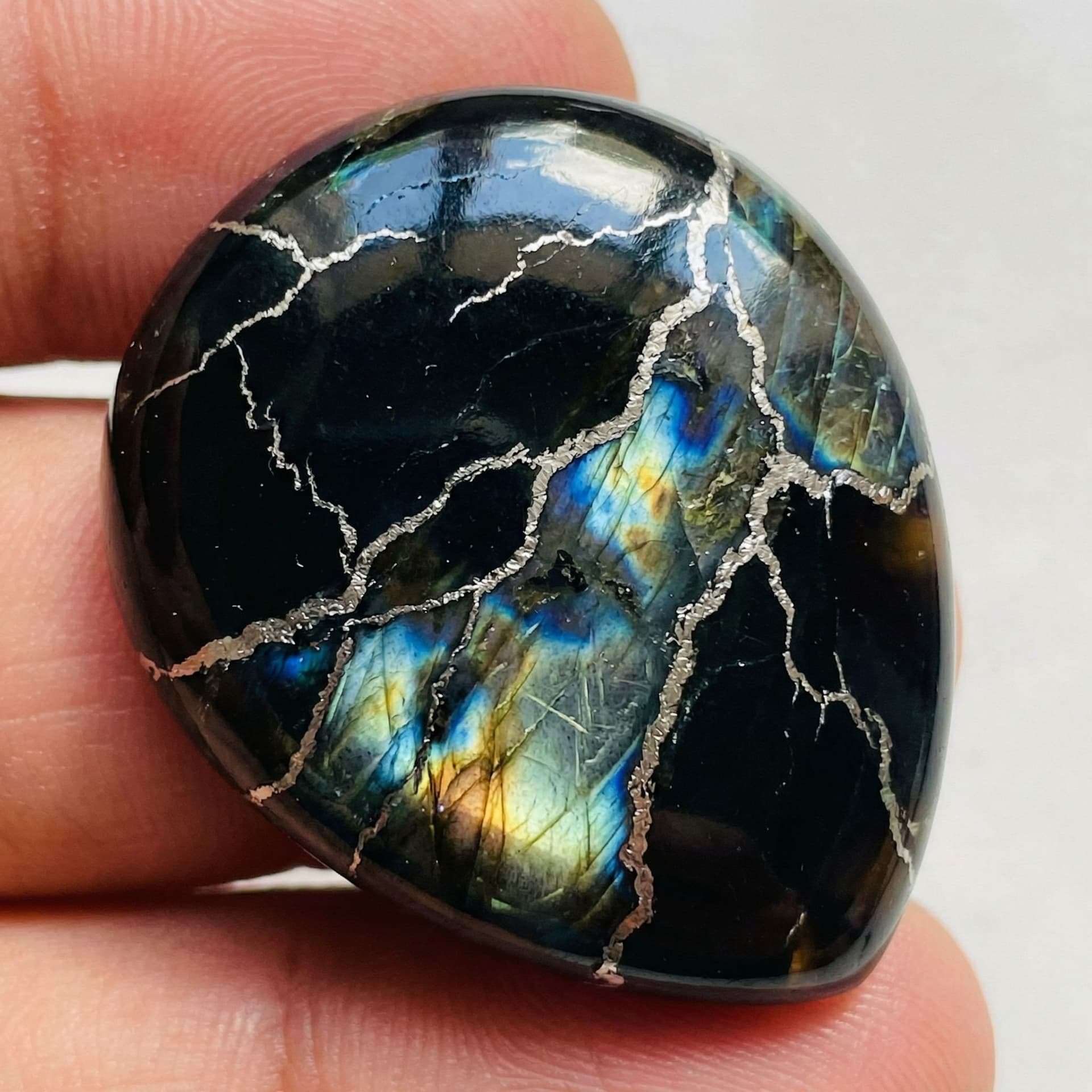 AI generated: Black obsidian with platinum veins flowing through it like lightening and it has a shine like Labrad...