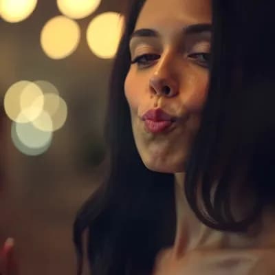 AI generated video: Blowing a kiss and putting her hand on her chest smiling naughty.