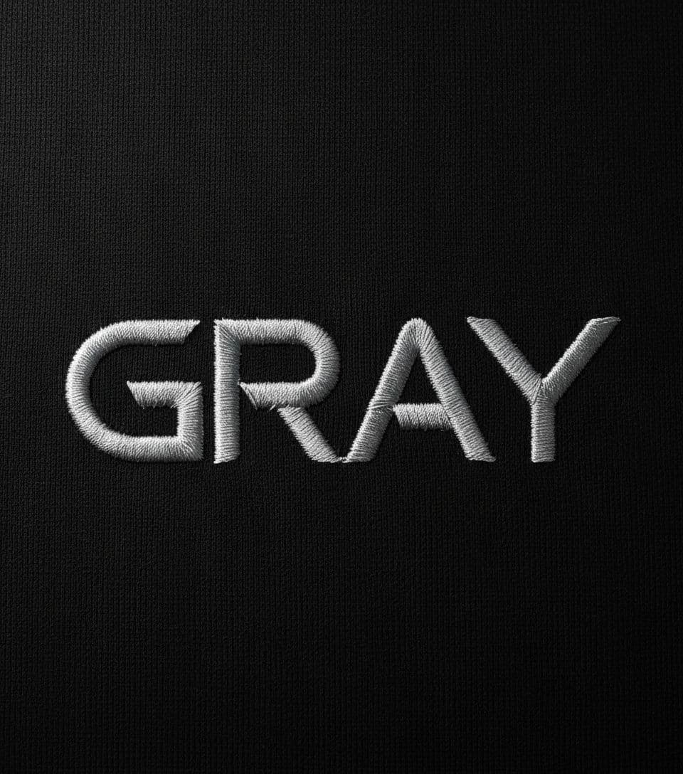 AI generated: photorealistic, top composition, silver color threads lettering "GRAY", on black clean textile, simp...