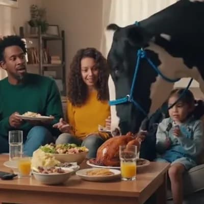 AI generated video: a video of a family eating in the living room while a cow is eating the food on the table
