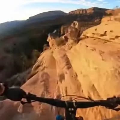 AI generated video: A realistic first-person video, filmed with a GoPro, of a professional athlete riding a bike down a ...