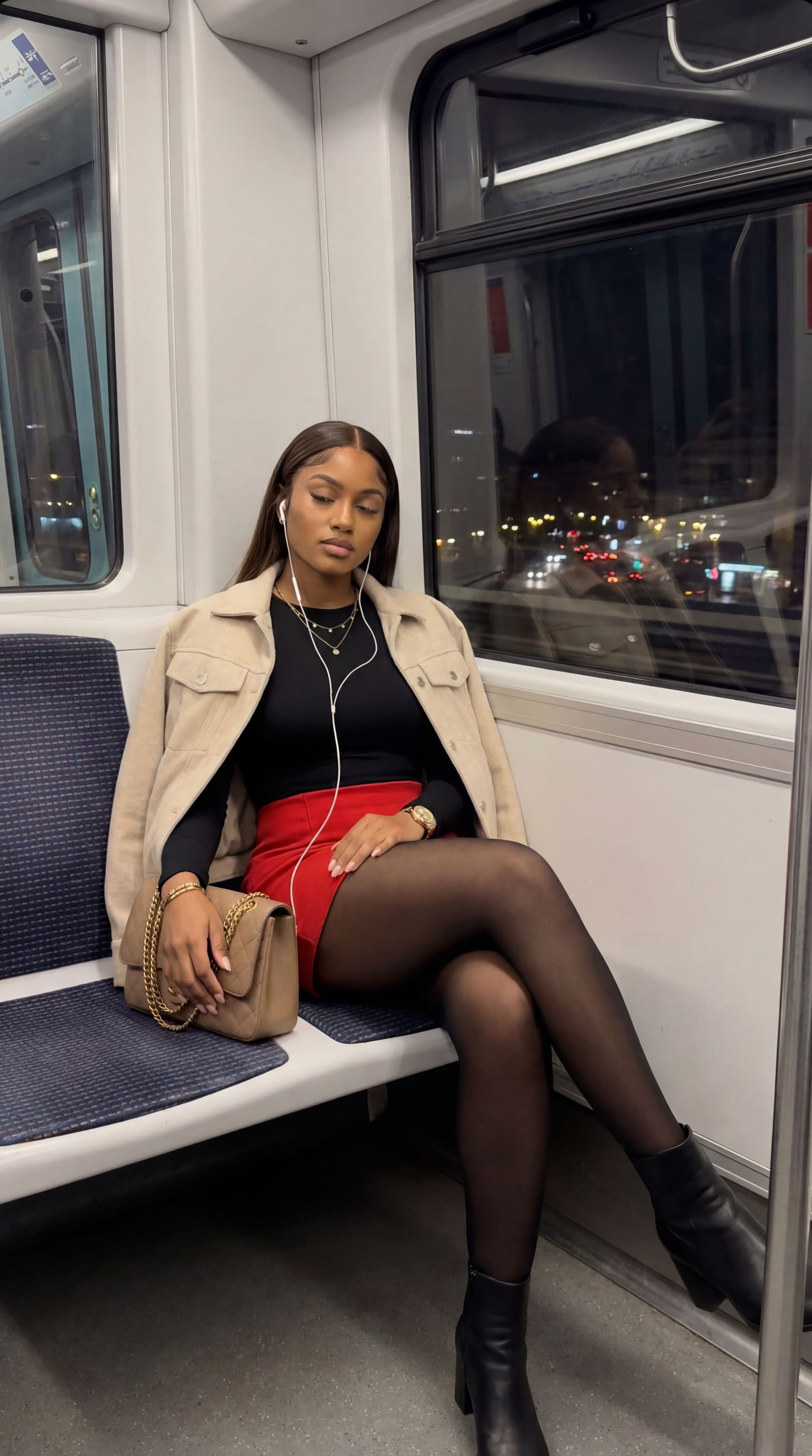 AI generated: A photo-realistic shot of the uploaded woman in a red mini skirt, black top and light jacket, seated...