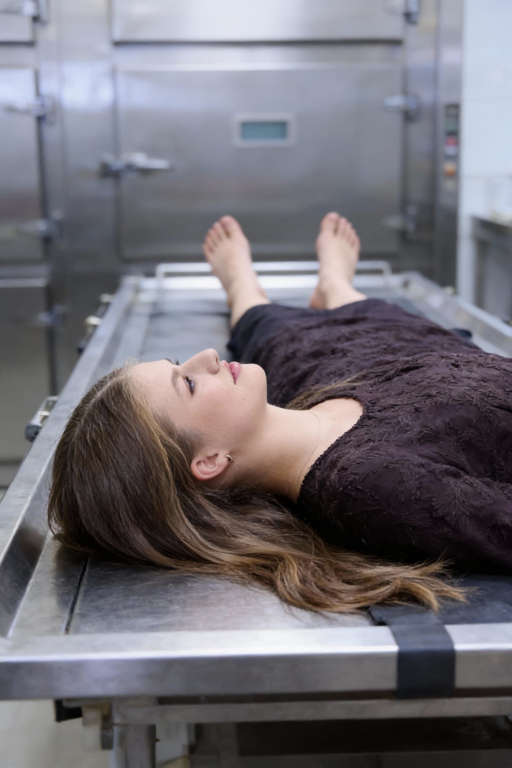 AI generated: dead girl lying on morgue table, , view from the side. bare feet