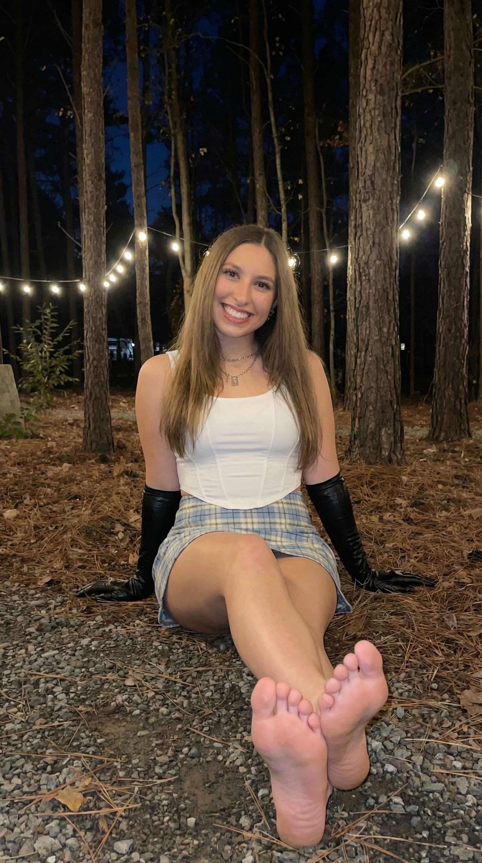AI generated: Use this girl and make her sitting down with her bare feet and soles showing in front of her