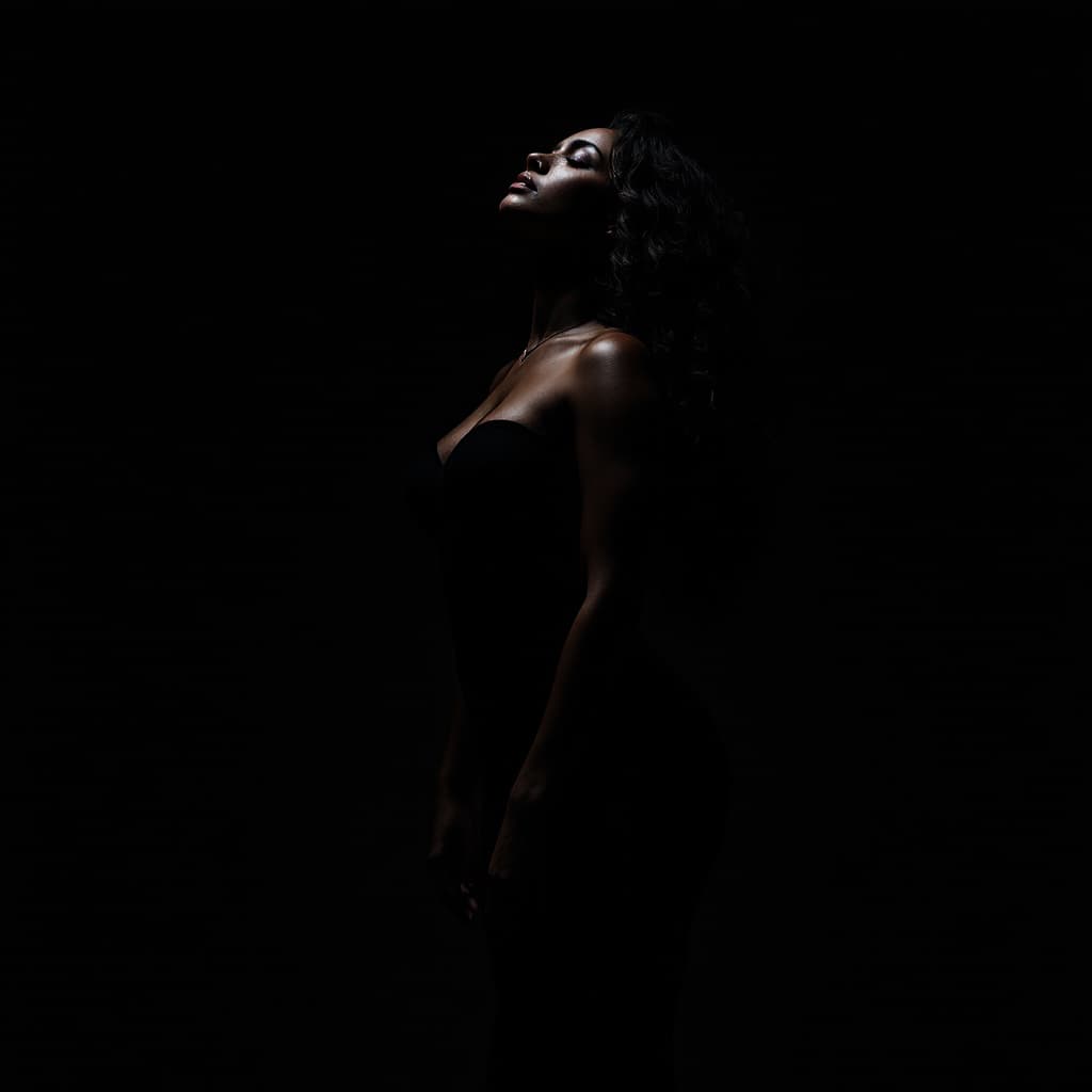 AI generated: A dark, intimate fine art portrait of a woman standing confidently against a deep, moody background....