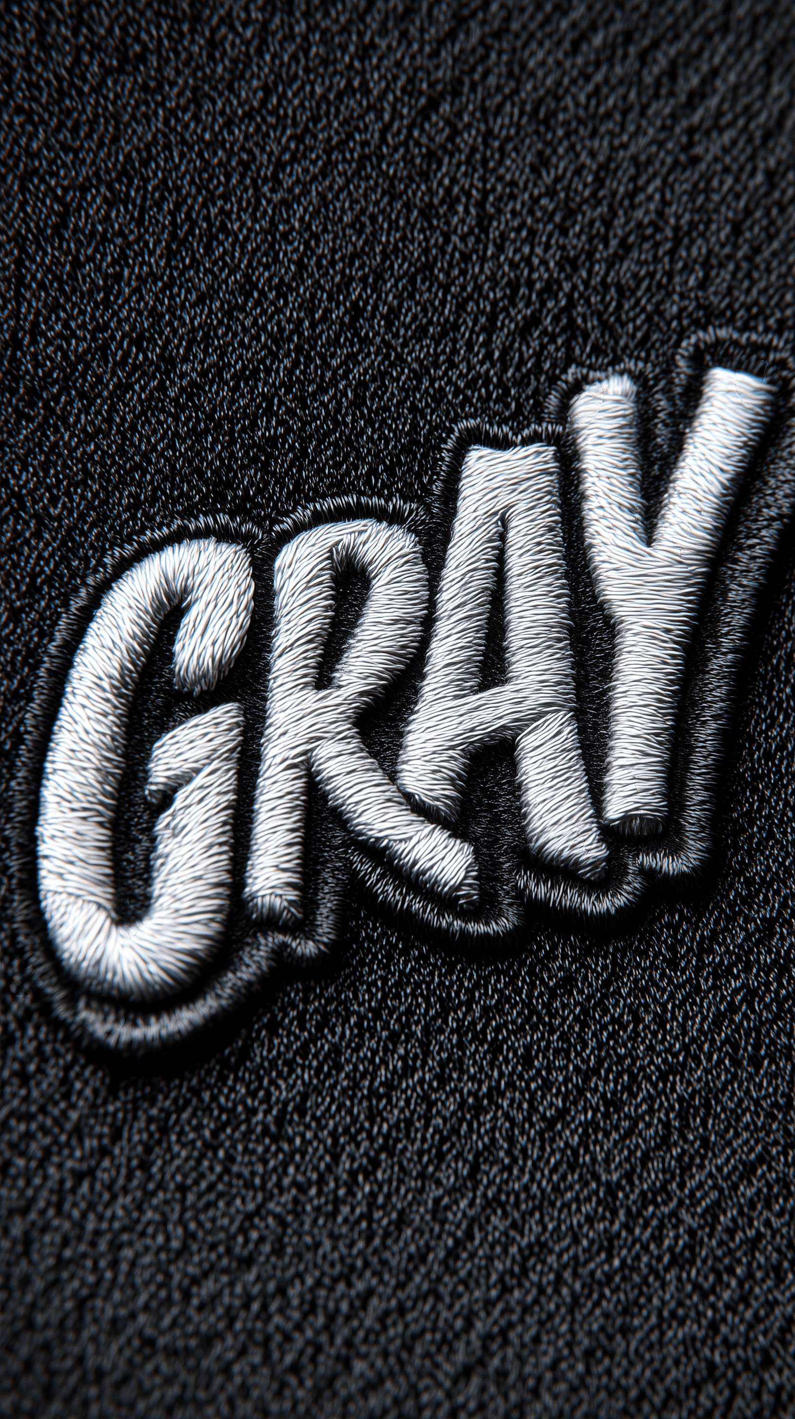 AI generated: photorealistic, top composition, silver color threads lettering "GRAY", on black clean textile, simp...