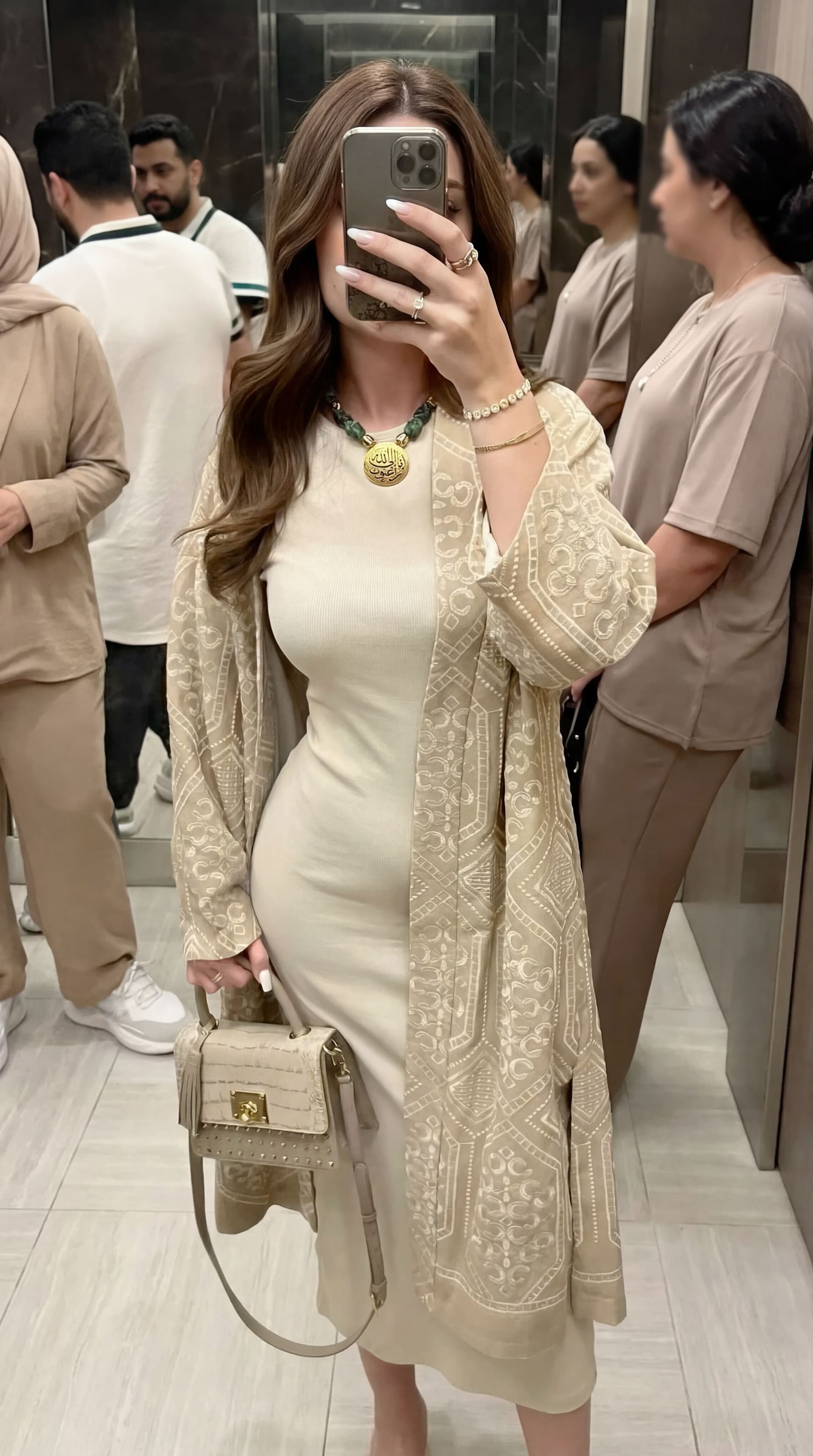 AI generated: Create an elegant female model taking a mirror selfie indoors. She wears a fitted cream-colored dres...