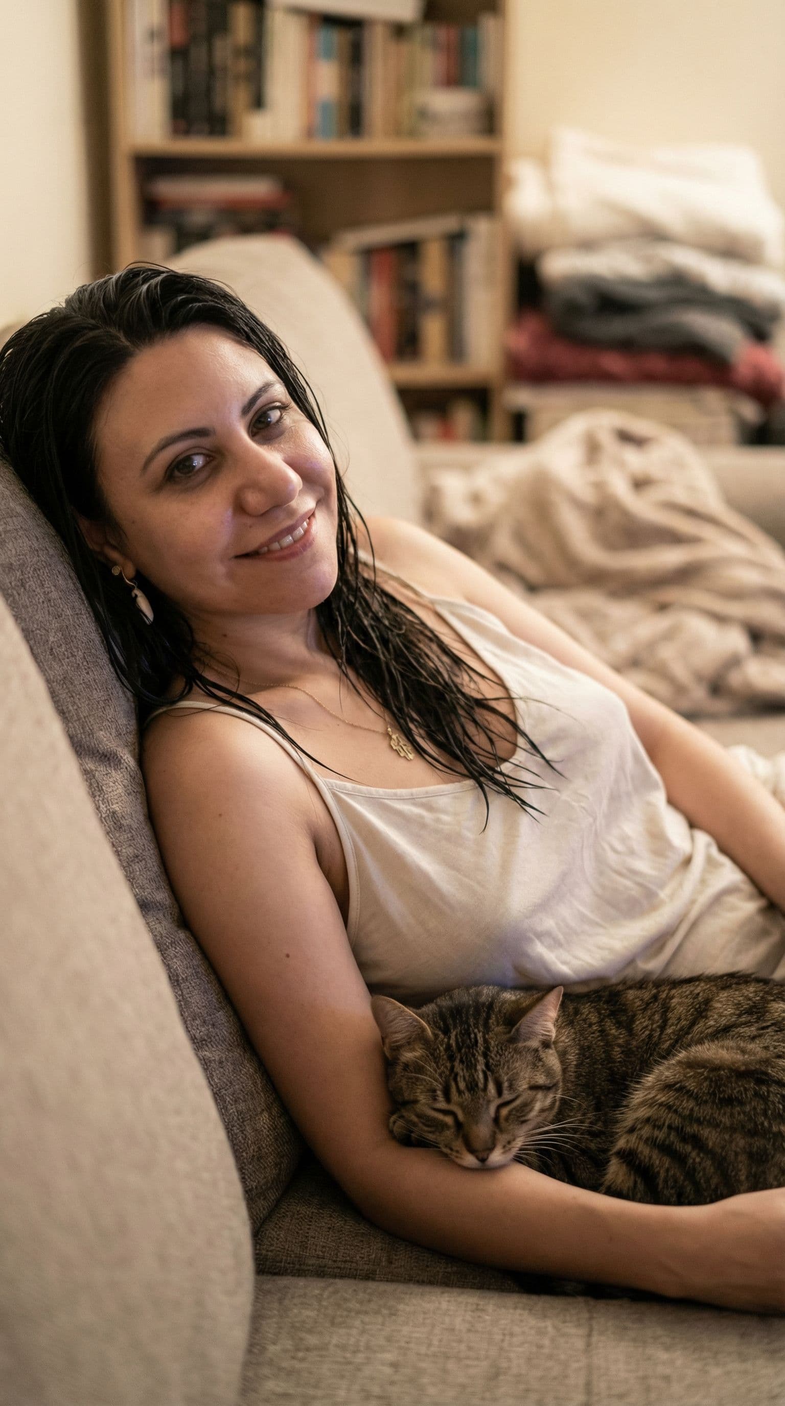 AI generated: Full body Portrait of a the uploaded  woman, sparsely dressed, wet hair, she is lying on the couch, ...