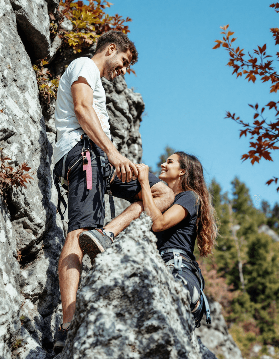 AI generated: A man and a woman, both light-skinned in their twenties, are positioned mid-rock climbing, holding h...