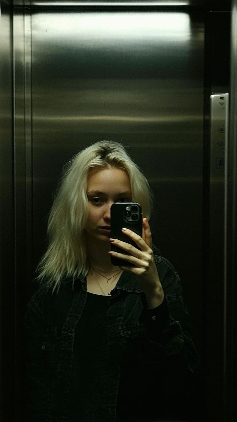AI generated: A 35 years old sweden woman, blonde hair, stands in front of a mirror, capturing a selfie. The image...